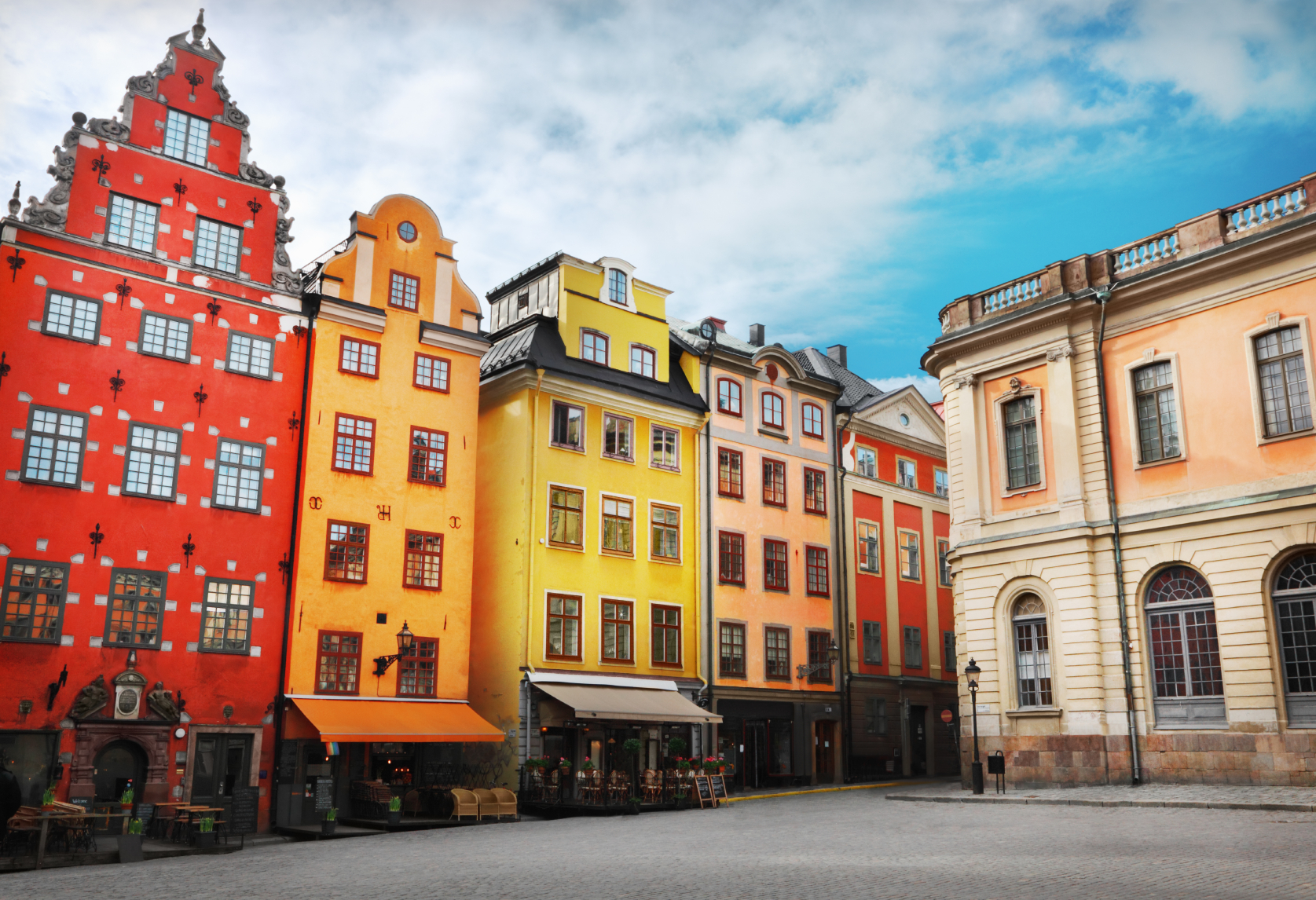 Stockholm's Old Town is shown as vibrant and colorful underneath a blue sky.